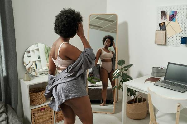 how long does wegovy take to work | woman looking in long-length mirror in bedroom