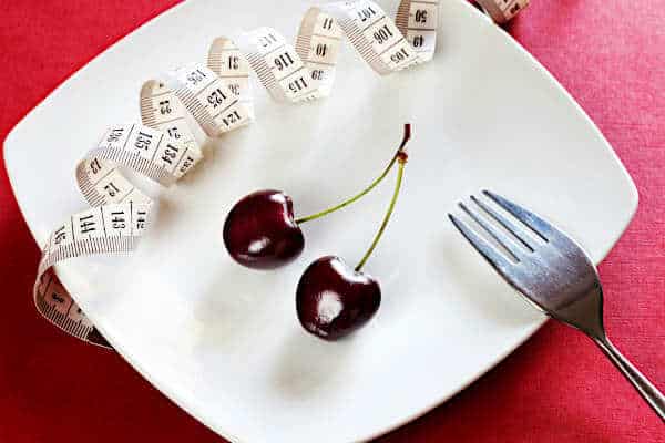 Can you eat too little on Mounjaro | plate with two cherries and a measuring tape