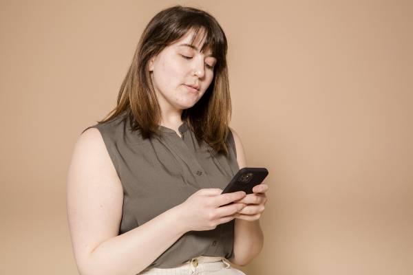 wegovy vs mounjaro side effects | woman in beige-green top looking at phone