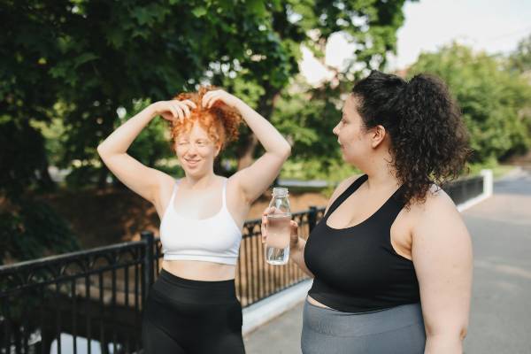 simple ways to move more | two women wearing exercise clothes walking in the park
