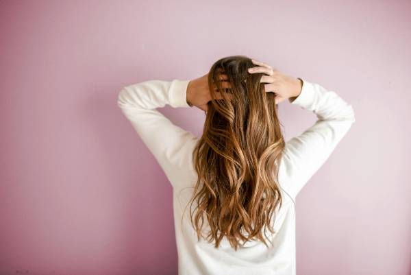 wegovy hair loss | back of woman's head with hands running through long hair
