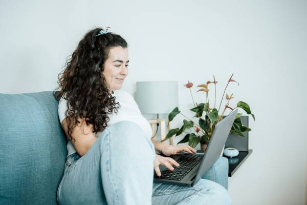 How Does Wegovy 7.2 mg Compare to Mounjaro? | woman on green-blue sofa with laptop